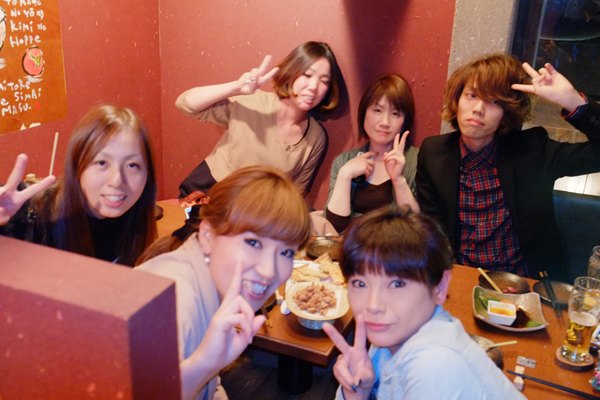 店を閉めたあとの食事。五人が並んで指を立てている