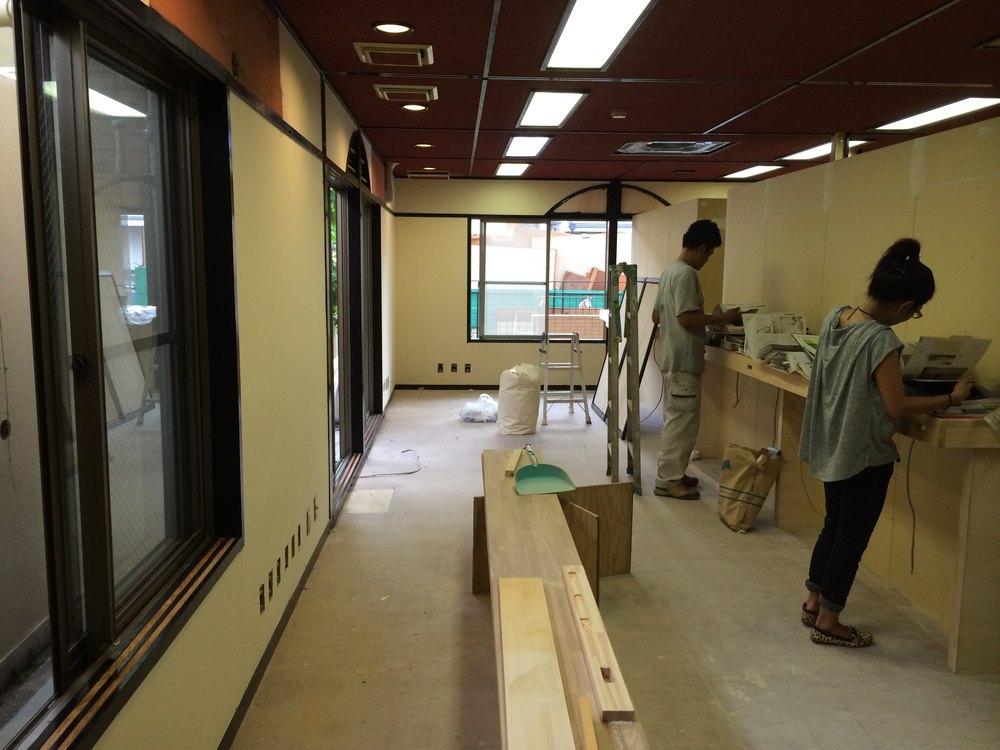 工事中の店内。窓辺で二人が作業している