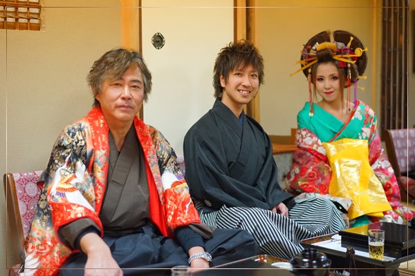 和室で、着物と洋装の三人が並んで座っている