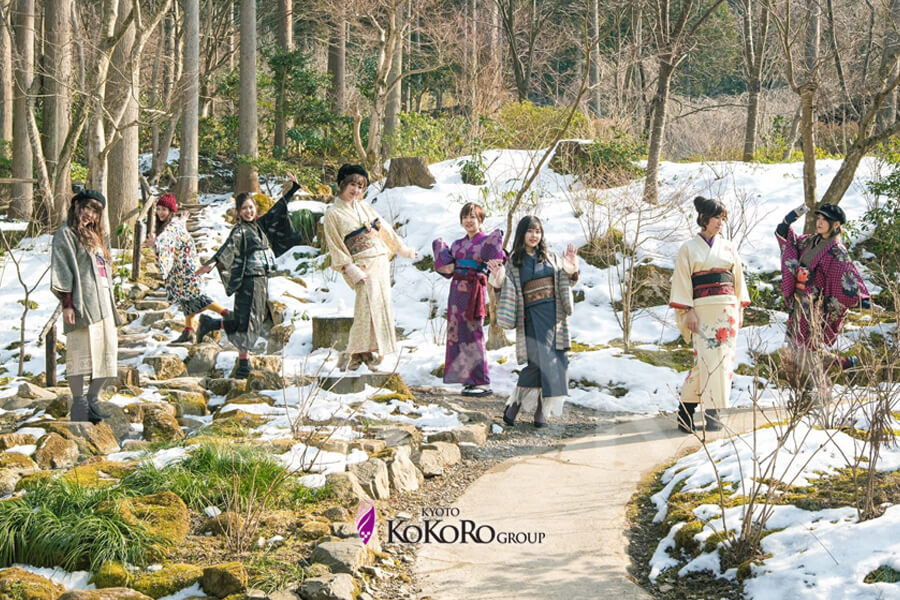 雪の残る山道を、着物の一行が歩いている