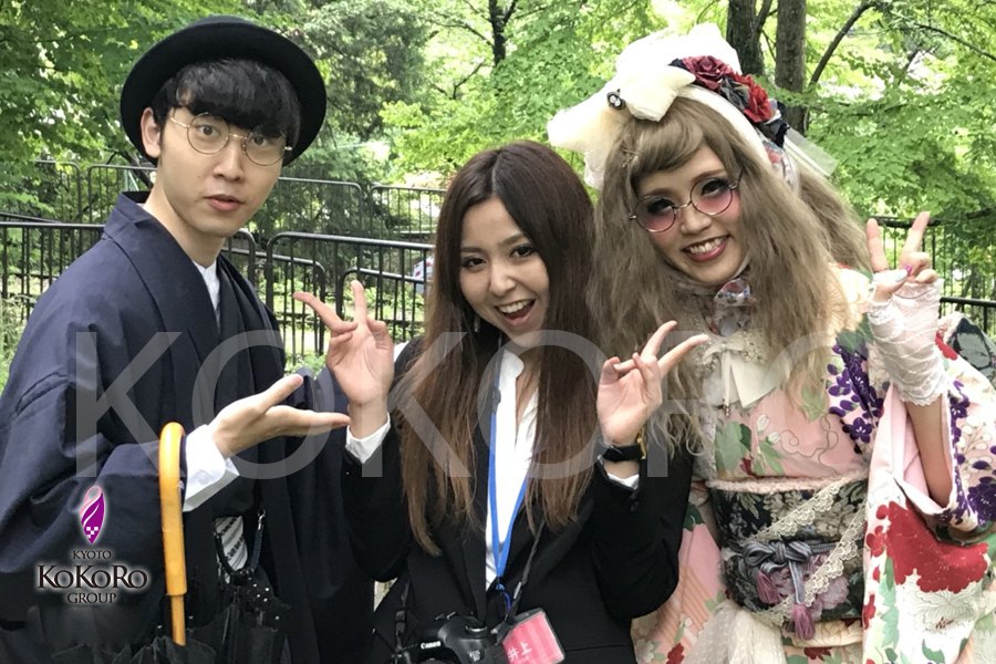 木立の前で、着飾った三人が並んでいる