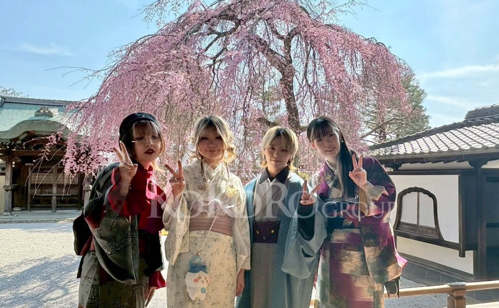 枝垂れ桜を背に、着物姿の四人が並んでいる