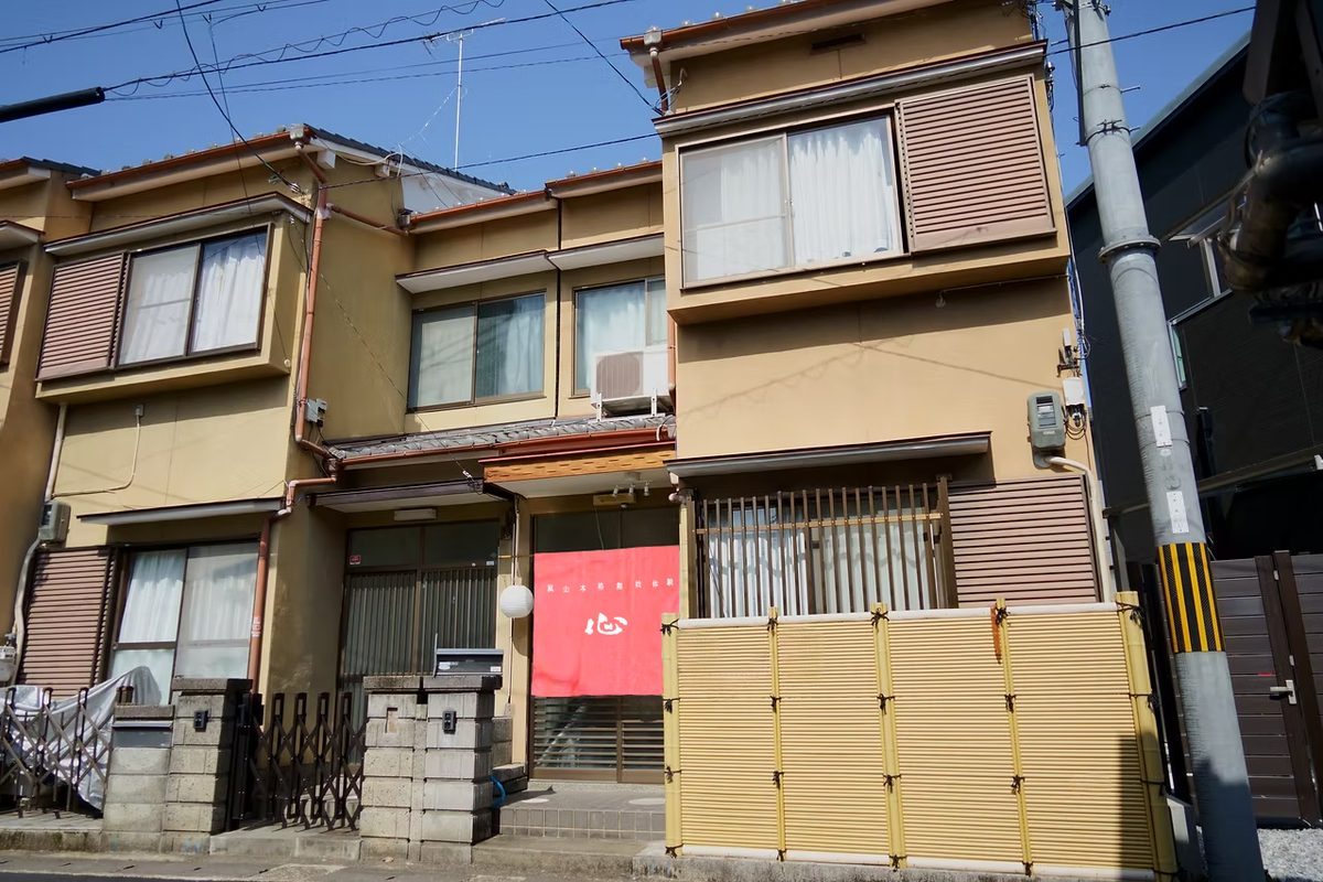 開業当時の嵐山店「本格舞妓体験処 心」の外観。町家に紅い暖簾が掛かっている