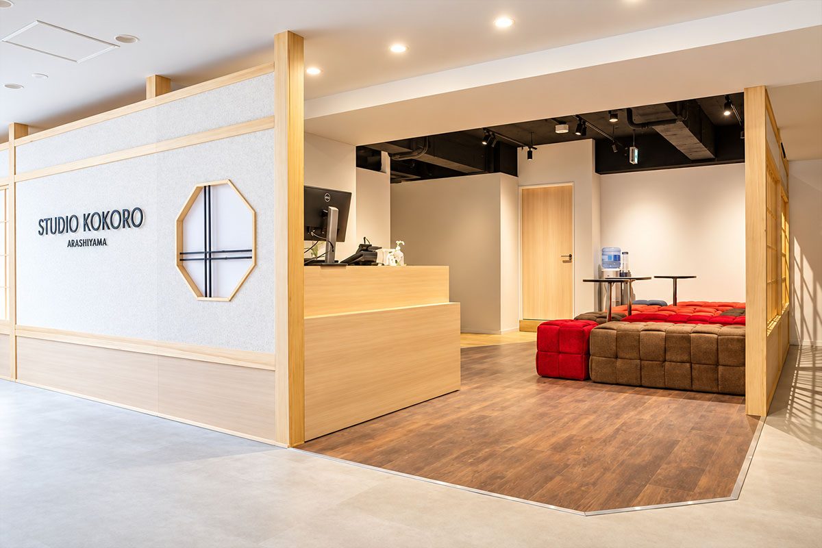 移転後の STUDIO KOKORO ARASHIYAMA の店内。白い壁の丸窓と、白木の受付台