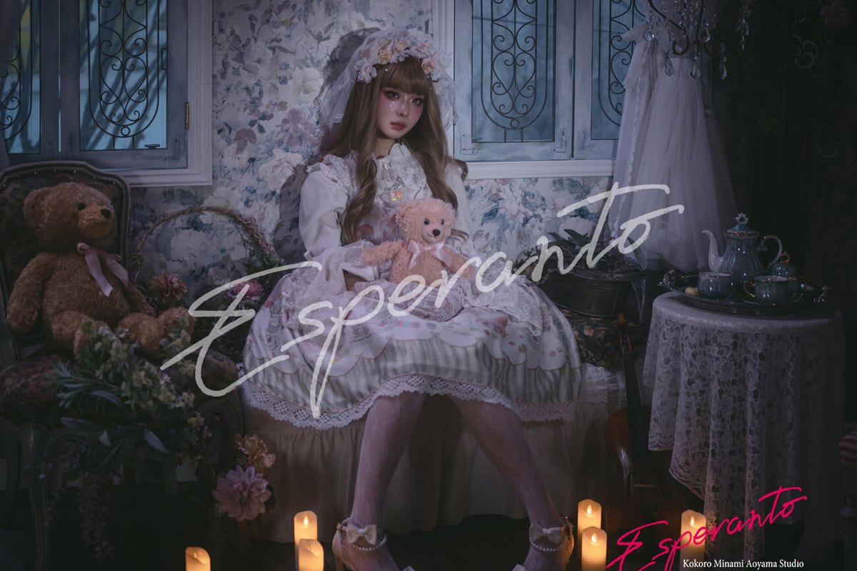 A guest dressed in white in a Western room, among candlesticks and a teddy bear.